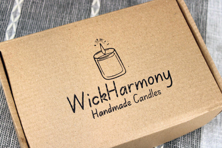 Kraft paper box with 'WickHarmony Handmade Candles' logo on a textured fabric background
