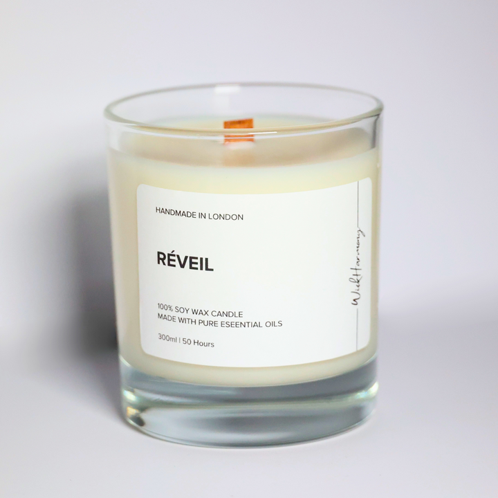 Réveil essential oil soy candle in a 300ml clear glass jar with wooden wick, handmade in London by WickHarmony. Made with basil, lemon, orange, and spearmint oils.
