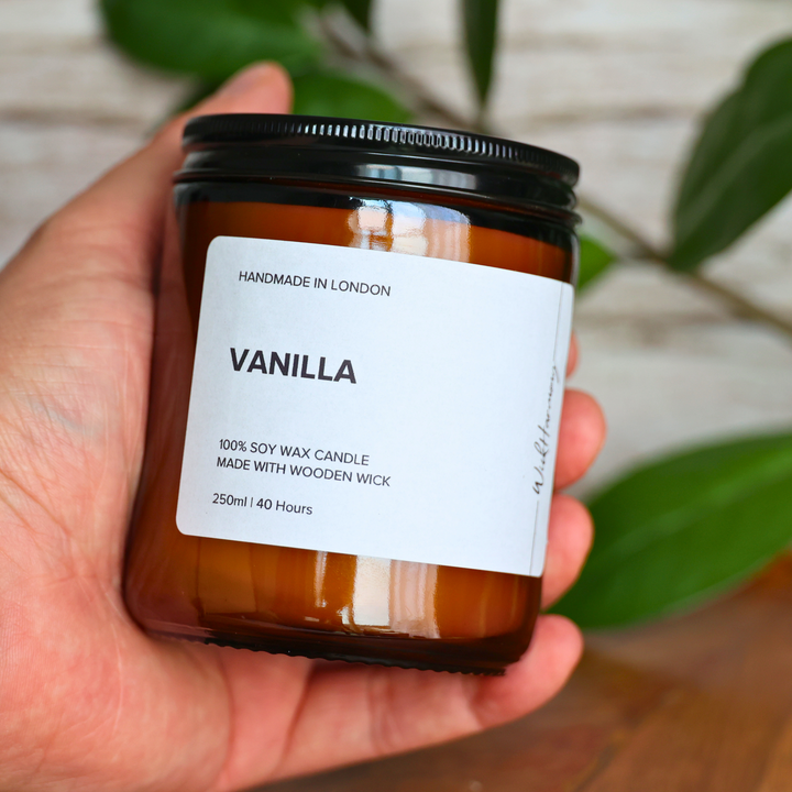 Person holding 250ml Vanilla soy candle in amber glass jar with minimalist label