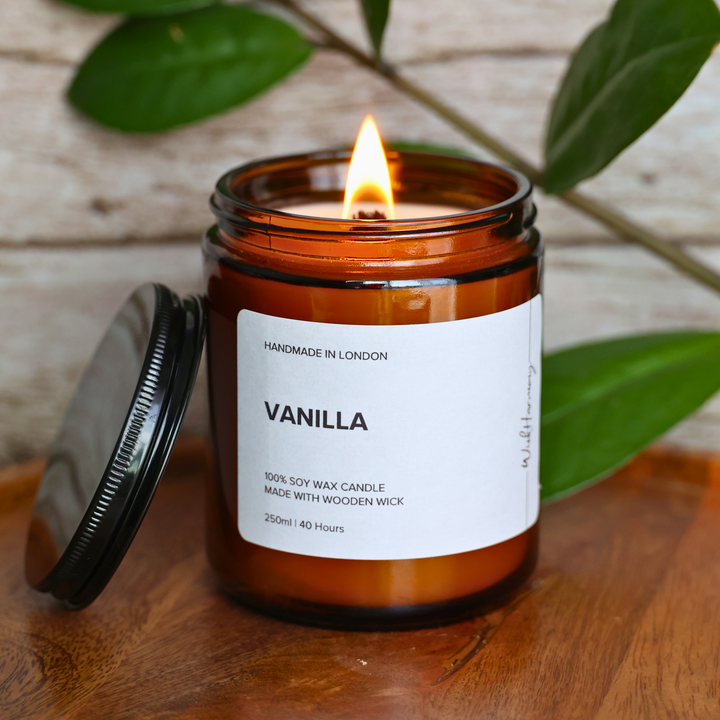 Vanilla soy candle burning in amber glass jar with wooden wick, 250ml variant